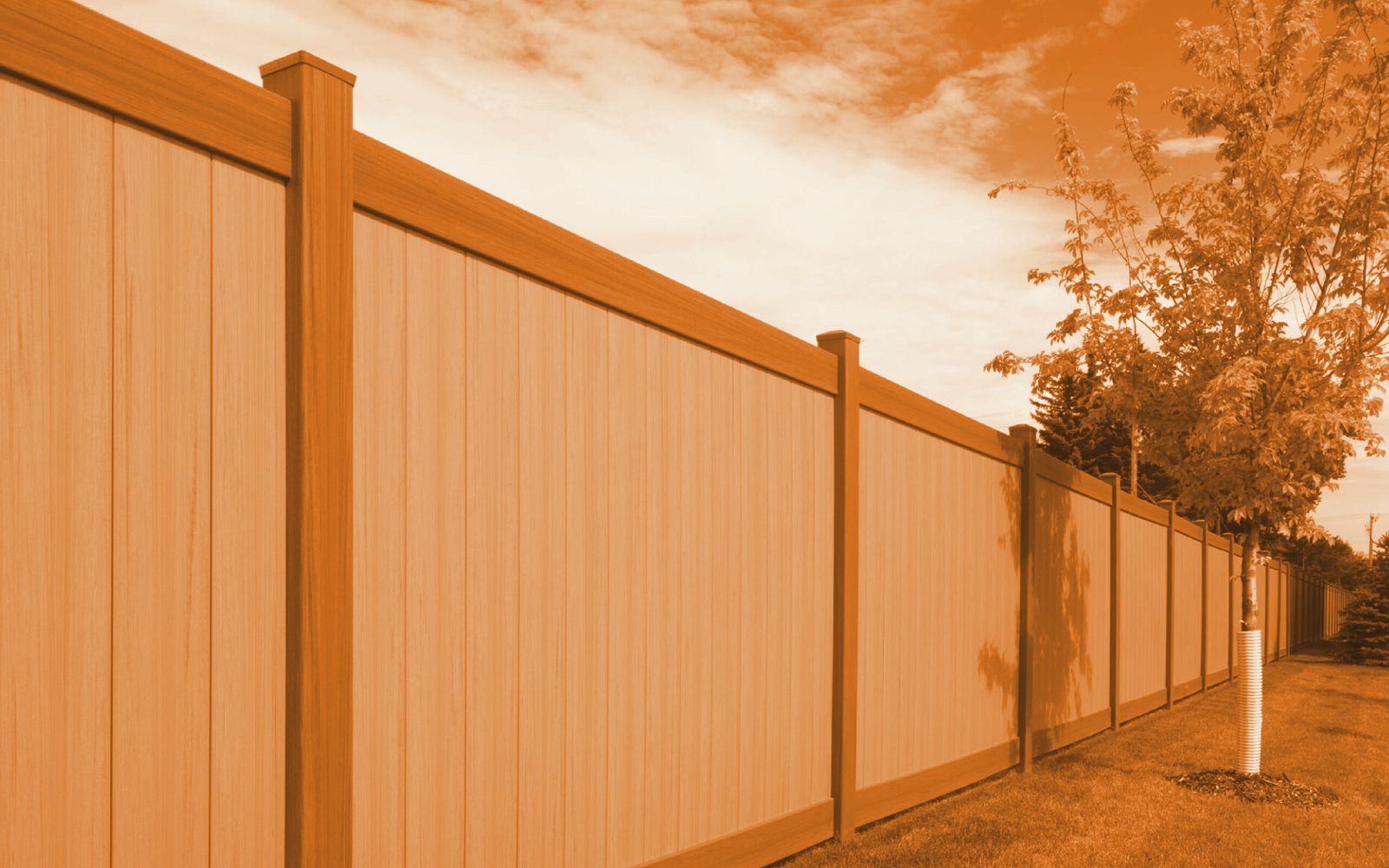 Two-tone vinyl privacy fence with dark rails installed by AG Vinyl Fencing